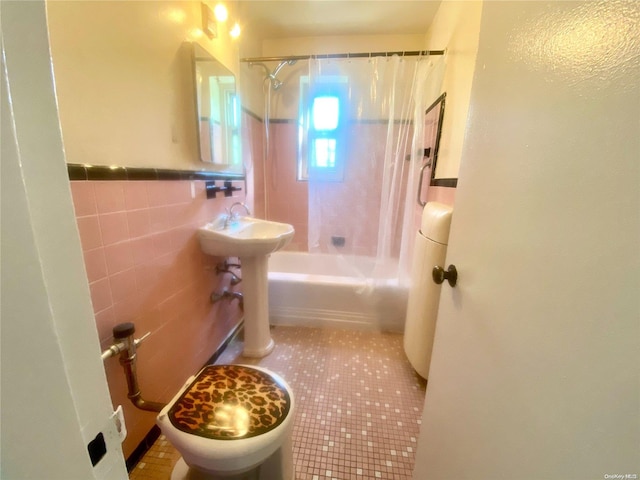 bathroom featuring tile patterned floors, shower / bath combo with shower curtain, and tile walls