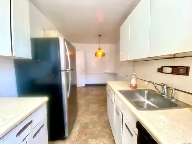 kitchen with stainless steel fridge, sink, white cabinets, and pendant lighting