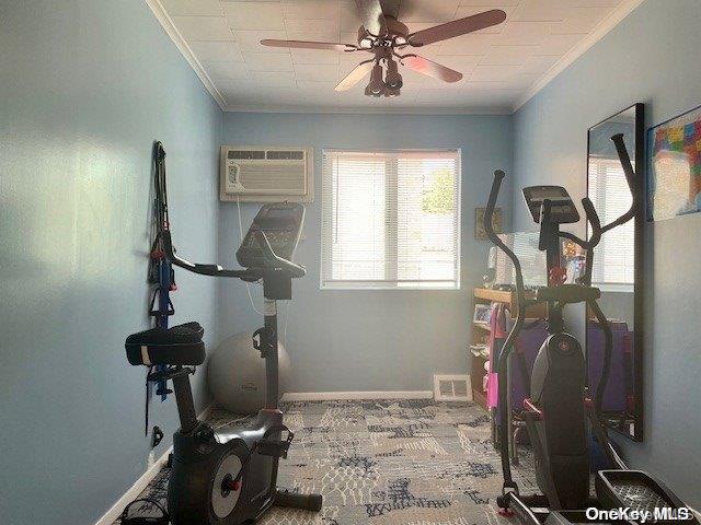 exercise area featuring a wall mounted AC, crown molding, and ceiling fan