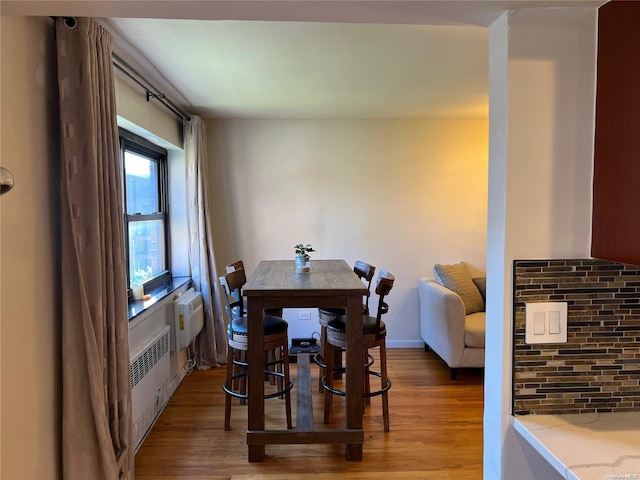 dining area featuring hardwood / wood-style flooring and radiator