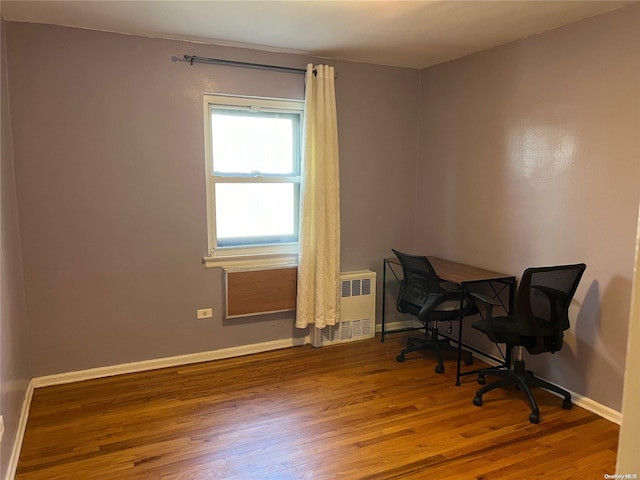 office space featuring radiator and hardwood / wood-style flooring