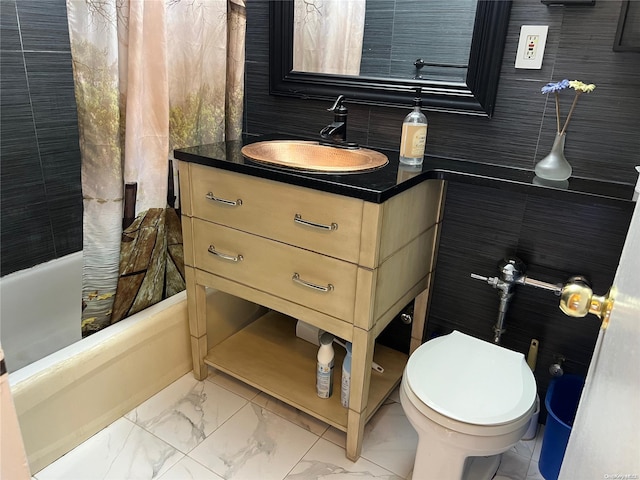 bathroom with vanity, toilet, and tile walls