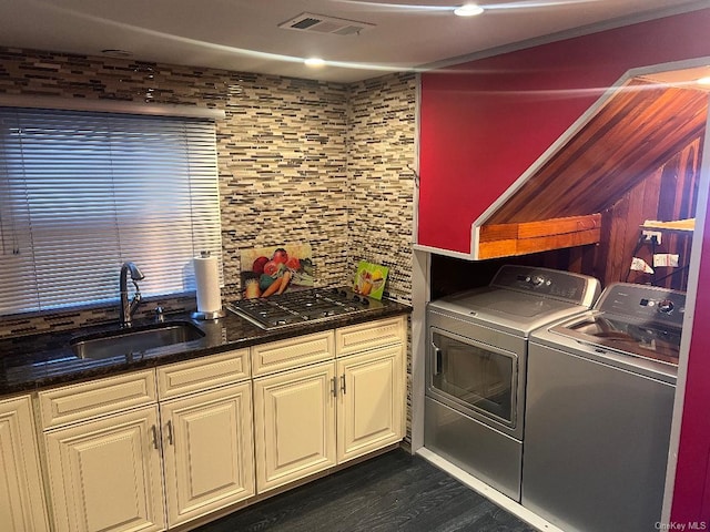 laundry room with washer and clothes dryer, dark hardwood / wood-style flooring, sink, and cabinets