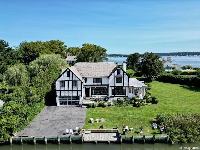 rear view of house with a yard and a water view