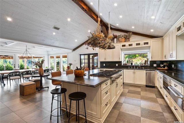 kitchen with lofted ceiling with beams, a center island, and plenty of natural light