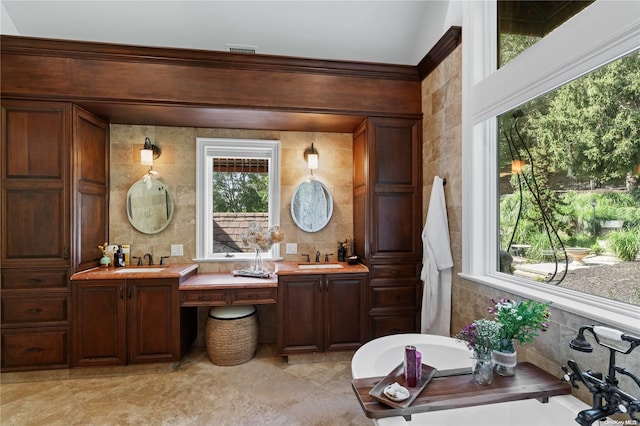 bathroom featuring vanity, a bath, and tile walls