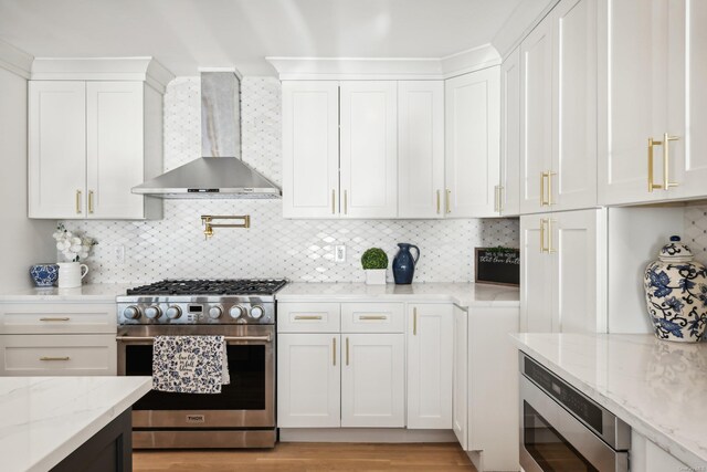 8 Shoal Dr, West Islip, NY 11795 - kitchen featuring appliances with stainless steel finishes, wall chimney range hood, and white cabinets
