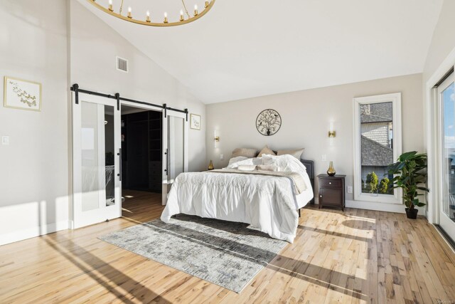 8 Shoal Dr, West Islip, NY 11795 - bedroom with wood finished floors, a barn door, and high vaulted ceiling