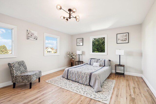 8 Shoal Dr, West Islip, NY 11795 - bedroom with multiple windows, a chandelier, and light wood-style flooring