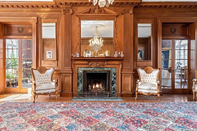 unfurnished room with a high end fireplace, french doors, a wealth of natural light, and wood walls