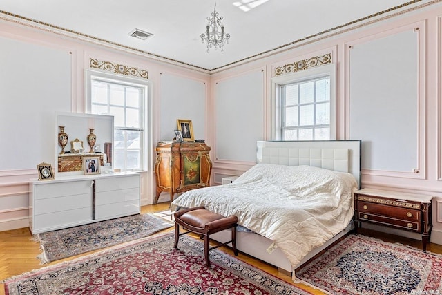 bedroom with multiple windows and light hardwood / wood-style floors