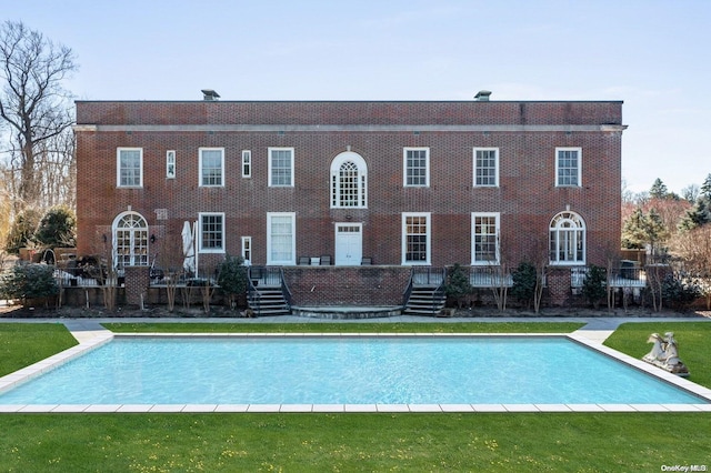 view of pool featuring a lawn