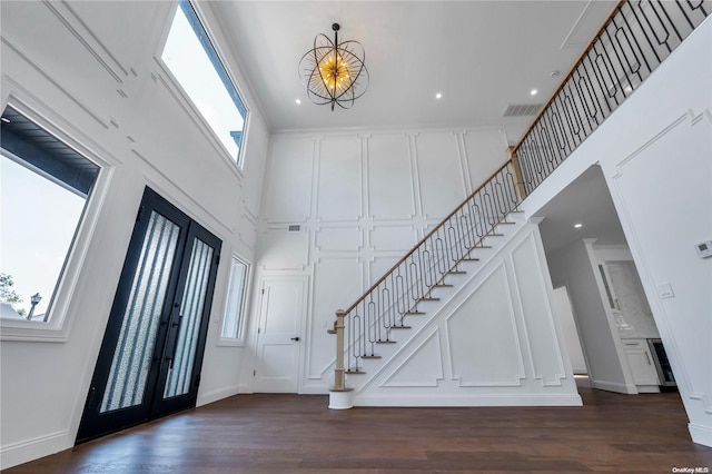 entryway featuring a healthy amount of sunlight, dark wood-type flooring, a high ceiling, and french doors