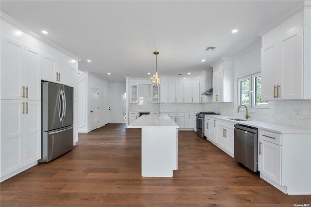 kitchen featuring stainless steel appliances, pendant lighting, white cabinets, a center island, and dark hardwood / wood-style floors