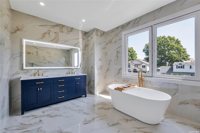 bathroom with vanity, a bath, and tile walls