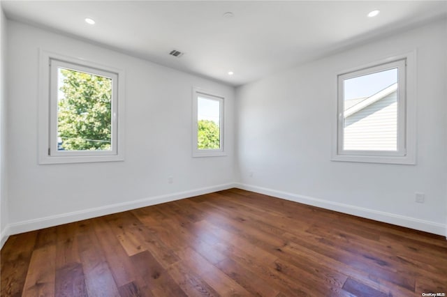 empty room featuring dark hardwood / wood-style flooring and a wealth of natural light