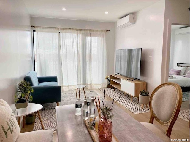 living room featuring a wall mounted AC and hardwood / wood-style floors