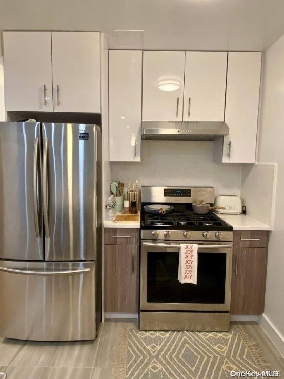 kitchen featuring light hardwood / wood-style floors, white cabinetry, and appliances with stainless steel finishes