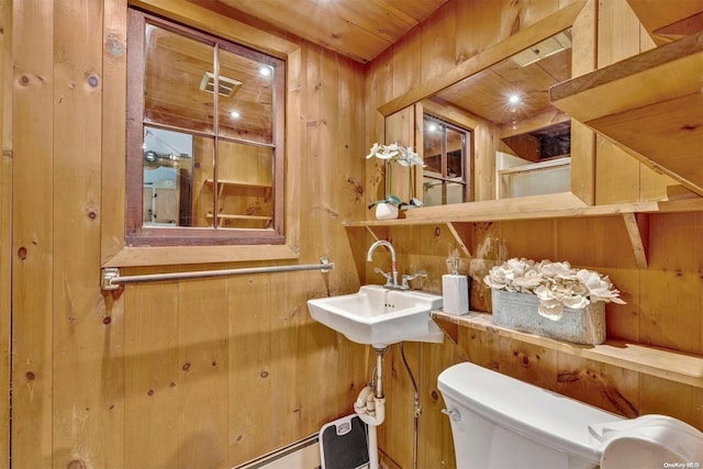 bathroom with wood walls, sink, wood ceiling, and toilet