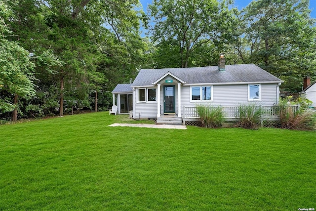 view of front facade with a front yard and a sunroom