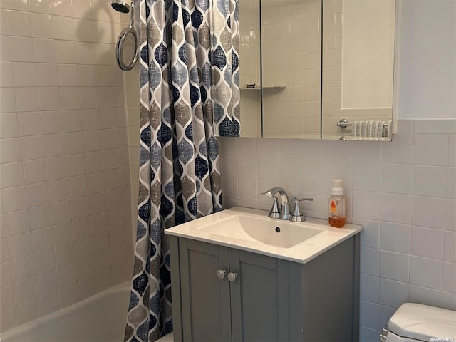 full bathroom featuring shower / bath combination with curtain, vanity, toilet, and tile walls