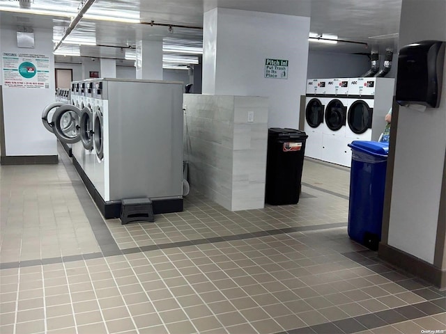 clothes washing area with light tile patterned flooring and washer and dryer