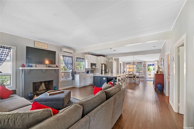 29 Ocean Rd, Ocean Beach, NY 11770 - living room with an AC wall unit, crown molding, hardwood / wood-style floors, and a brick fireplace