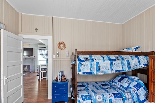 29 Ocean Rd, Ocean Beach, NY 11770 - bedroom with dark hardwood / wood-style floors, an AC wall unit, and wooden walls