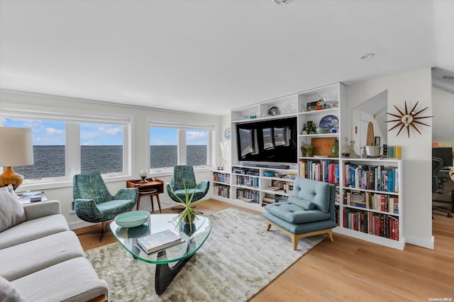 living room with hardwood / wood-style flooring and a water view