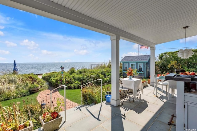 view of patio featuring a water view and an outdoor structure