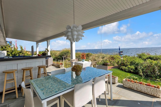 view of patio featuring a water view and exterior bar