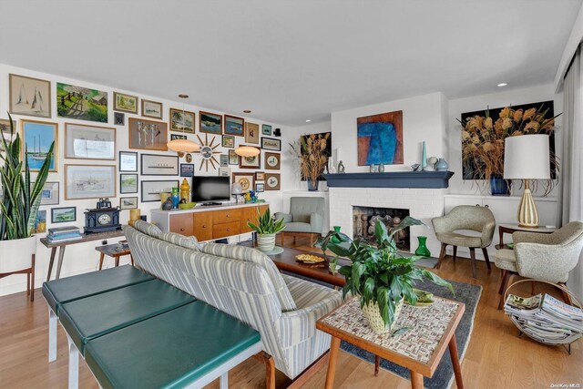 living room featuring a brick fireplace and hardwood / wood-style floors