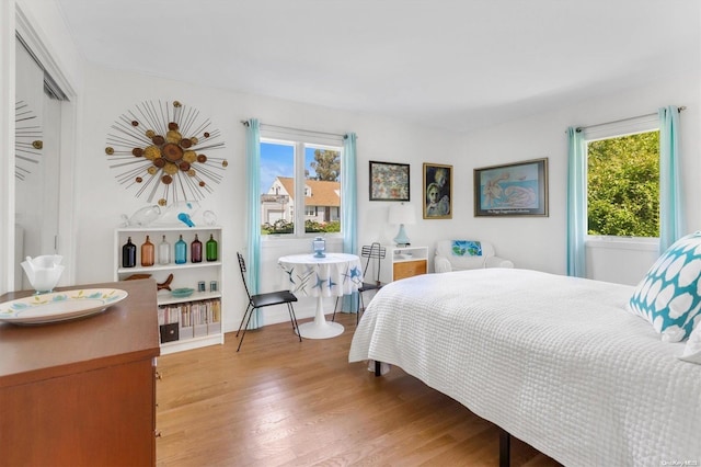 bedroom with multiple windows and light hardwood / wood-style flooring