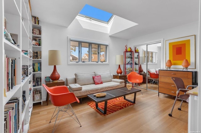 sitting room with a healthy amount of sunlight, light hardwood / wood-style floors, and a skylight