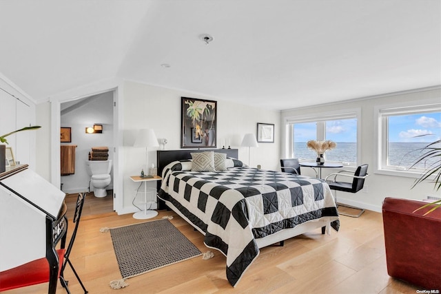 bedroom featuring a water view and light wood-type flooring