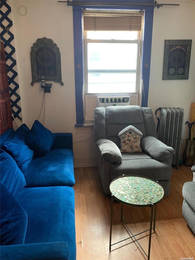 12-28 150th St, Whitestone, NY 11357 - living room featuring radiator heating unit, wood finished floors, and baseboards