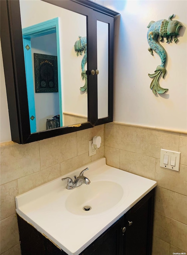 bathroom featuring vanity and tile walls