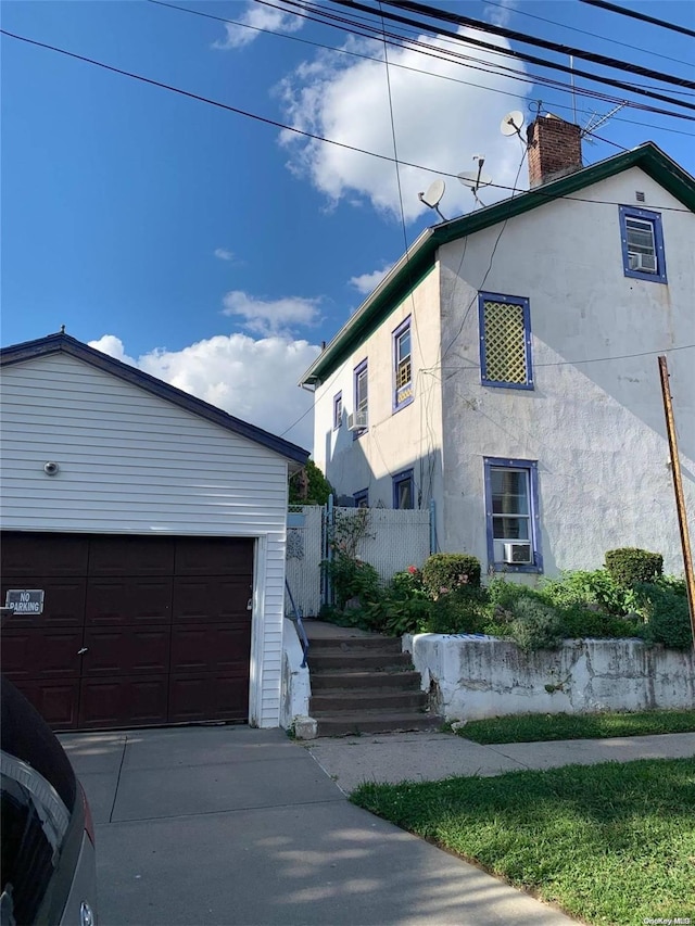 view of home's exterior featuring a garage and an outbuilding