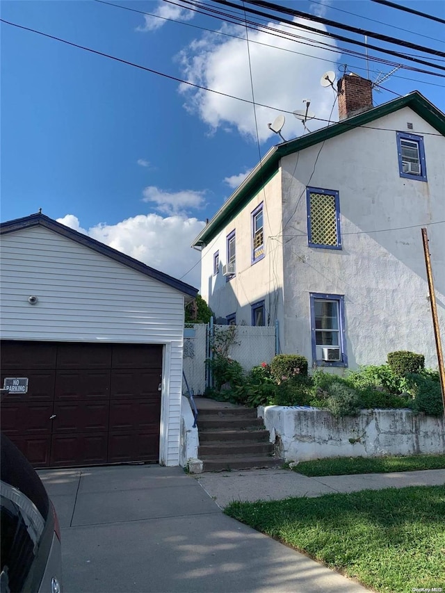 12-28 150th St, Whitestone, NY 11357 - view of side of home with a chimney, stucco siding, and an outdoor structure