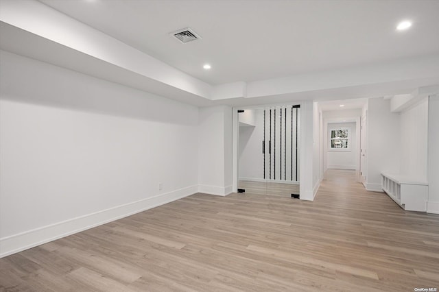 basement with light hardwood / wood-style flooring