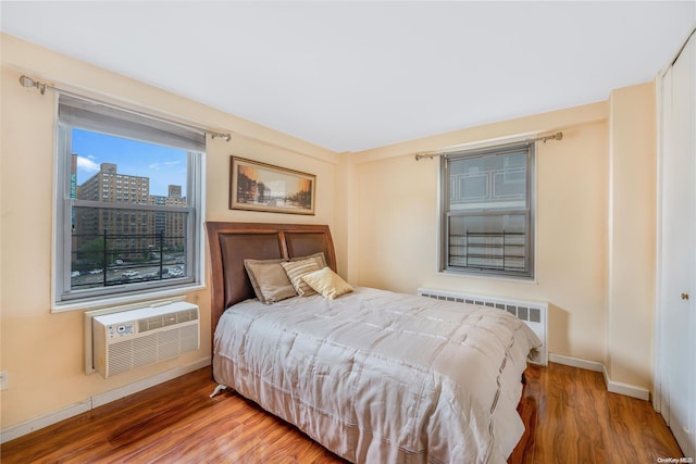 61-15 97th St Unit 5A, Rego Park, NY 11374 - bedroom with radiator, a wall mounted AC, wood finished floors, and baseboards