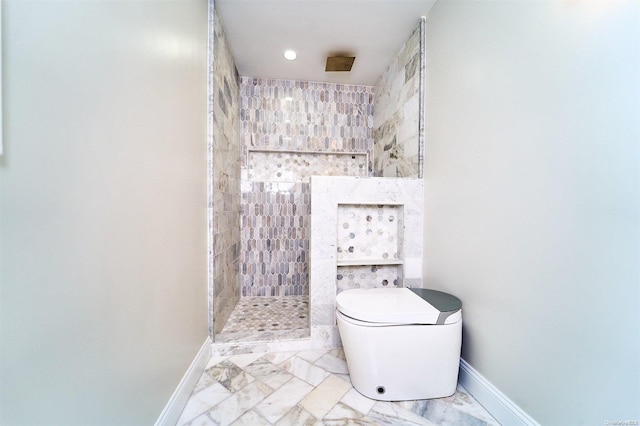 bathroom featuring toilet and a tile shower