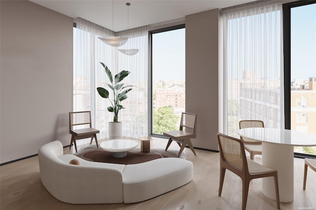 sitting room with light wood-type flooring and floor to ceiling windows