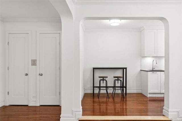 details featuring backsplash, crown molding, sink, and wood-type flooring