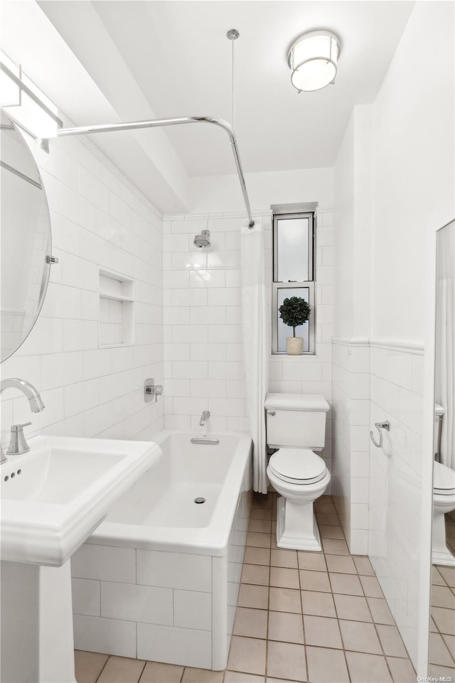 full bathroom with tile patterned floors, sink, toilet, tile walls, and shower / tub combo