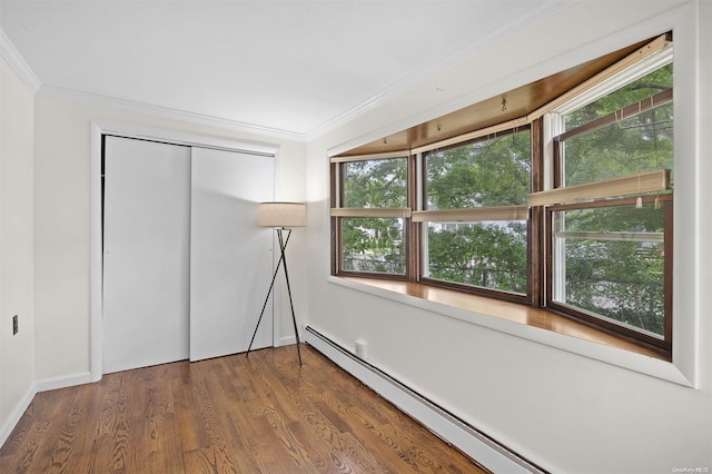 unfurnished bedroom featuring dark hardwood / wood-style flooring, ornamental molding, baseboard heating, and a closet