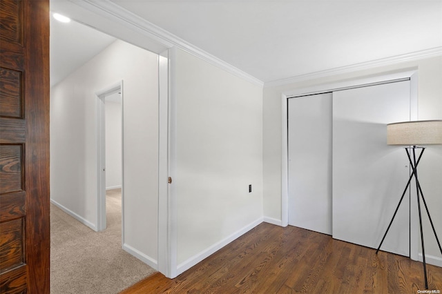 unfurnished bedroom featuring crown molding, a closet, and dark wood-type flooring