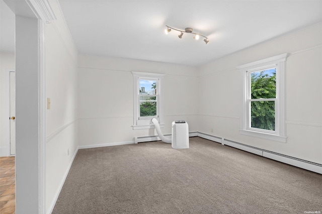 carpeted empty room with a baseboard radiator and plenty of natural light