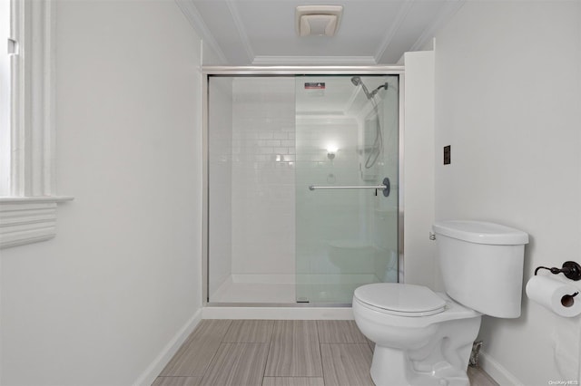 bathroom with toilet, ornamental molding, and a shower with door