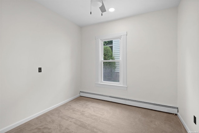 carpeted spare room with ceiling fan and a baseboard radiator